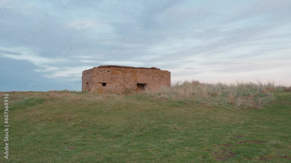 Fixed establishing clip of historic world war shelter on the English coastline at sunset. Fixed establishing clip of historic world war shelter on the English coastline at sunset.