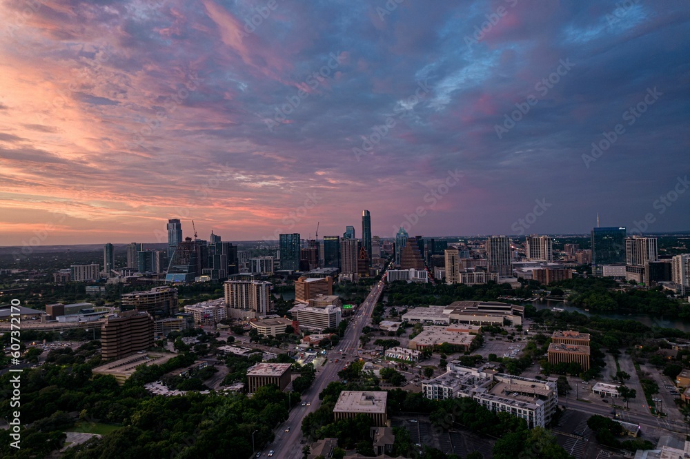 Drone shot of Austin cityscape under cloudy sky at dusk in Texas