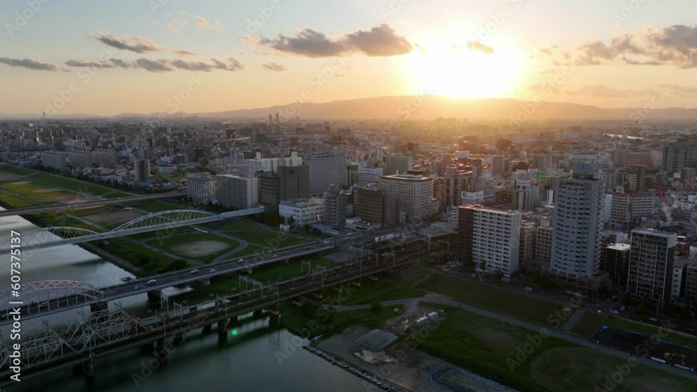 beautiful aerial view of Osaka at sunset, Osaka skyline with skyscrapers and train on a bridge over Yodogawa river, tourism in Japan