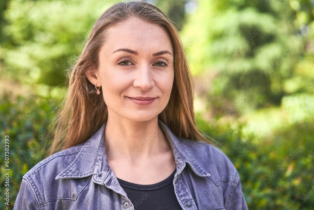 A woman's parkside smile radiates joy and serenity, embracing the beauty of the moment. A woman's parkside smile radiates joy and serenity, embracing the beauty of the moment.