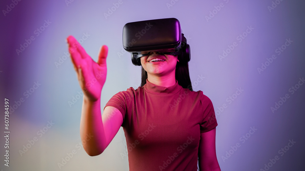 Cheerful young Asian Indian woman wearing a virtual reality headset, girl with vr glasses concept studio portrait