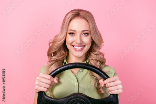 Photo of positive cute person beaming smile arms hold wheel steering isolated on pink color background