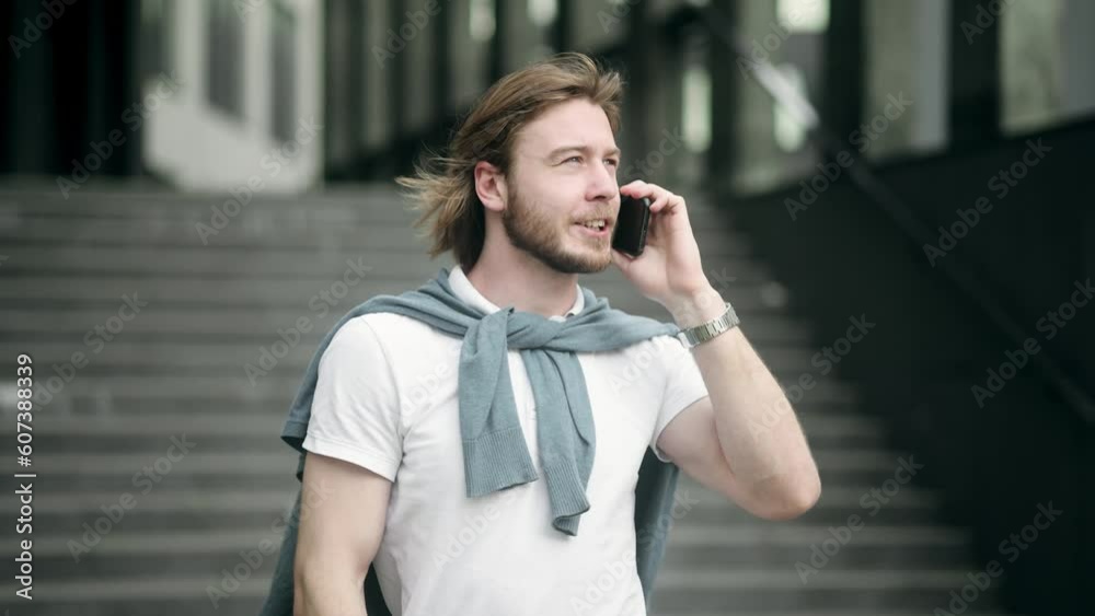 Happy successful male entrepreneur talking mobile phone walking along business district. Successful businessman going to work Happy successful male entrepreneur talking mobile phone walking along business district. Successful businessman going to work