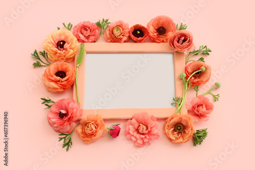 top view of pink flowers and wooden empty frame over pastel background. For mock up, copy space