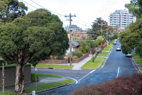 Photography Elevated view of a quiet suburban street with trees, Australian homes and modern apartment buildings in the distance