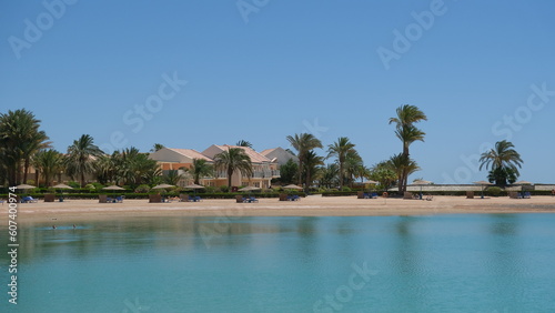 Idyllic Scenic Aerial view of El Gouna lagoon and sea , Umbrella and Sea chairs on the sand with palm trees and houses or mansion in the background , Hurgada , Red sea, Egypt Travel