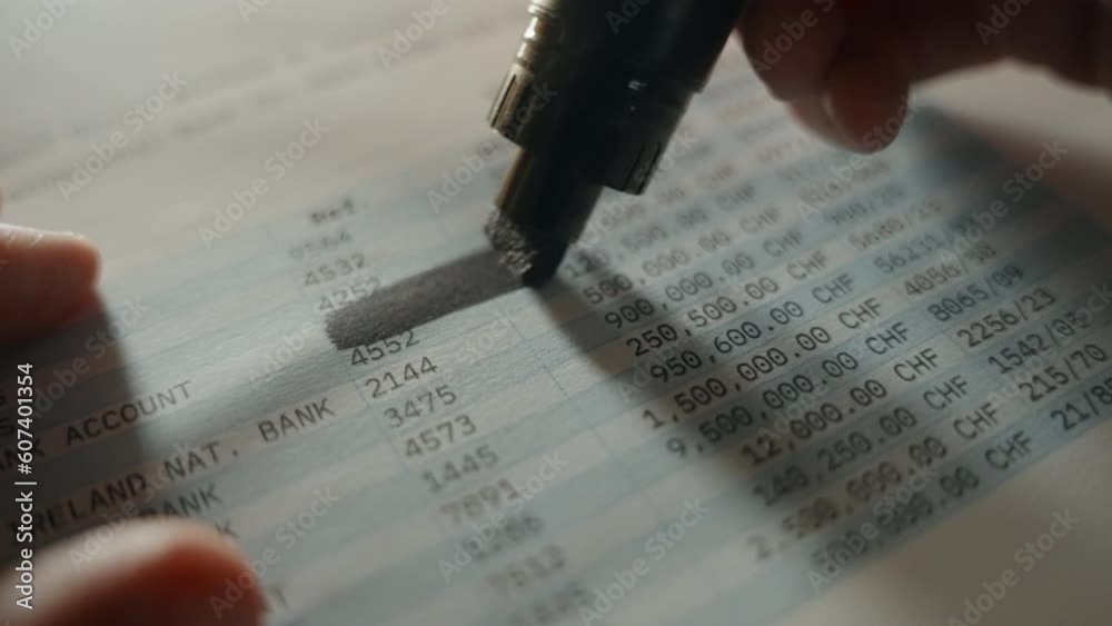 Hand uses black marker to redact parts of official bank account activity report. Erasing and hiding information for public eye by blacking out numbers and account information. Spy or agency operation