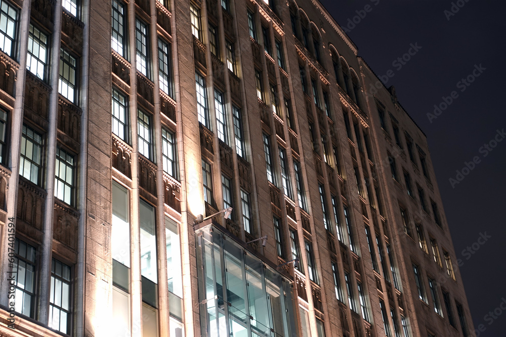 Exterior façade of a concrete building with windows and a glass entrance at night in Montreal Exterior façade of a concrete building with windows and a glass entrance at night in Montreal