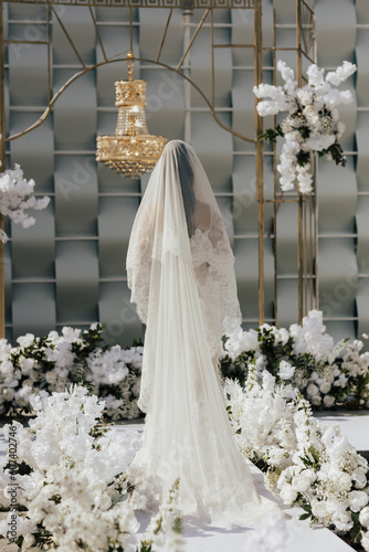 Obraz na płótnie A bride in a white wedding dress stands in front of a luxury elegant wedding decoration. w salonie