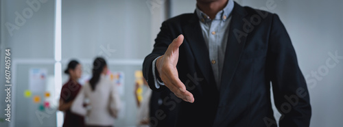 Asian businessman open hand offering handshake in office. Support of business concept. Shaking hands.