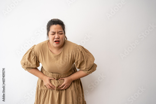 Obraz na plátně Young Asian plus size woman hand on stomach because nausea, painful disease feeling unwell,  may develop gallstones or Cholecystitis