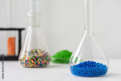 Plastic factory laboratory. Glass flasks with colored dye in granules for plastics. polymer industry.