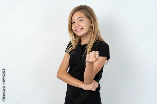 beautiful teen girl wearing black dress over white studio background Beckoning come here gesture with hand inviting welcoming happy and smiling