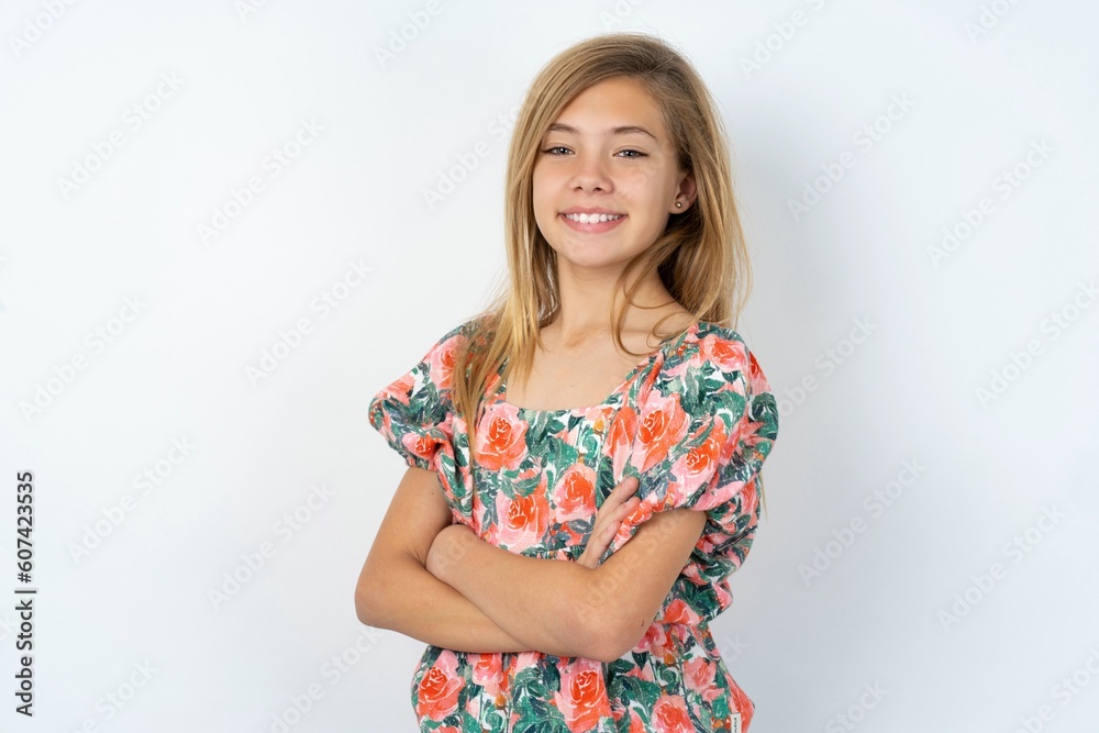 beautiful teen girl wearing flowered dress over white studio background happy face smiling with crossed arms looking at the camera. Positive person. beautiful teen girl wearing flowered dress over white studio background happy face smiling with crossed arms looking at the camera. Positive person.