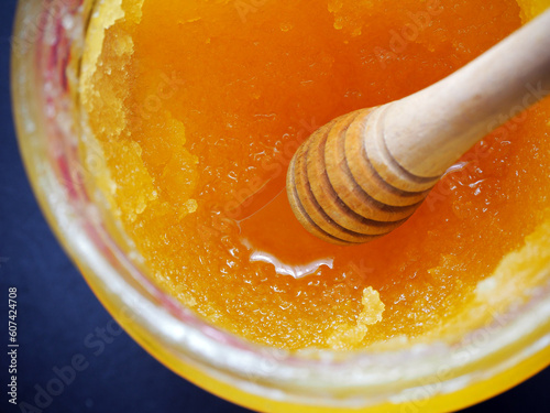 Caramelized honey dripping from a wooden spoon