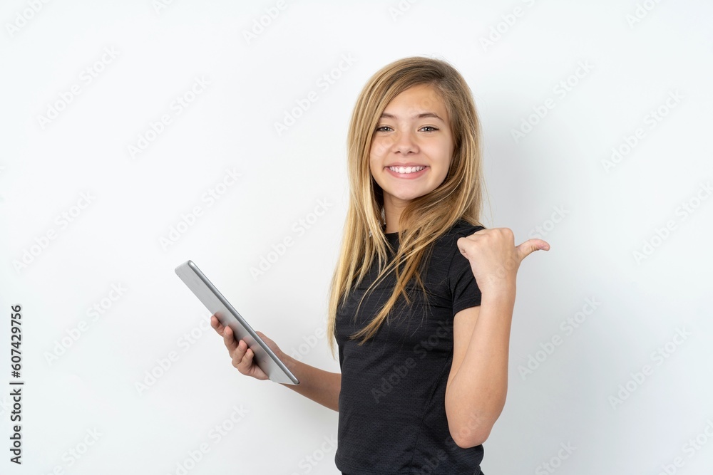 beautiful caucasian teen girl wearing sportswear over white wall pointing empty space modern device beautiful caucasian teen girl wearing sportswear over white wall pointing empty space modern device