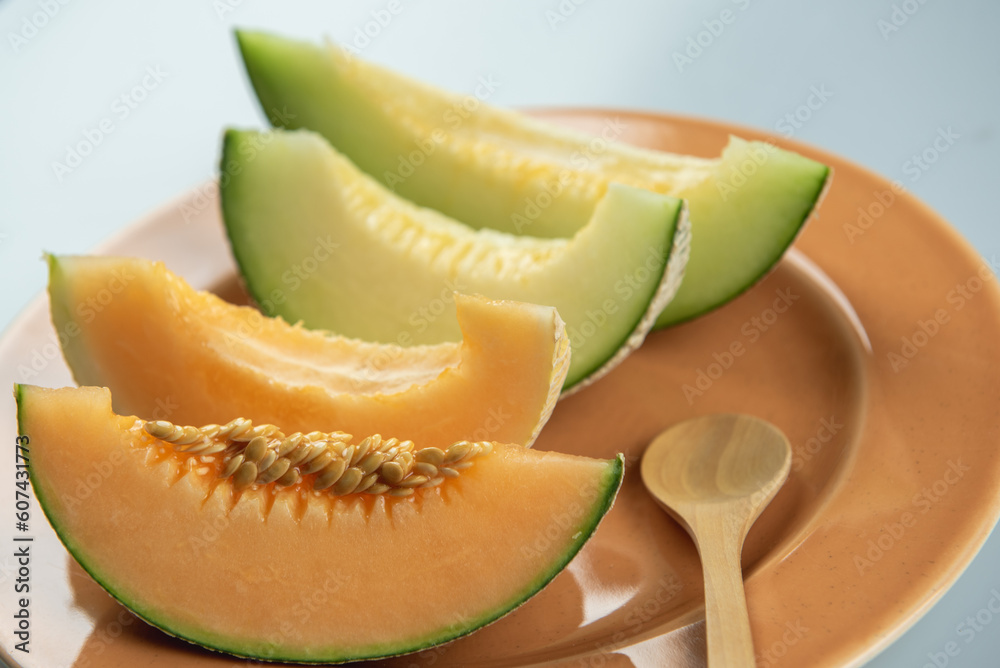 Honeydew melon and Japanese melon slice fresh ripe orange and sweet green slice lay on leaf in plant. Melon or cantaloupe is sweet fruit dessert. Honeydew melon and Japanese melon slice fresh ripe orange and sweet green slice lay on leaf in plant. Melon or cantaloupe is sweet fruit dessert.