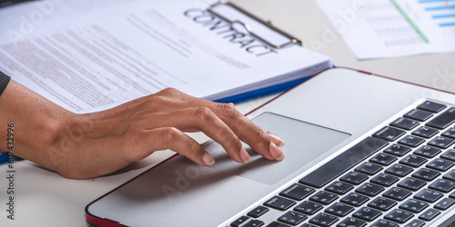 legal adviser reading examine draft contract in notebook and paper