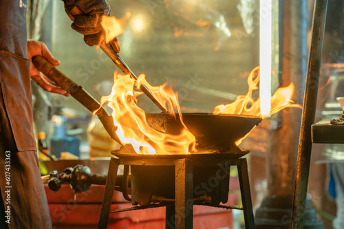 Wall Mural fried noodles cook in pan with big fire flame is hong kong style