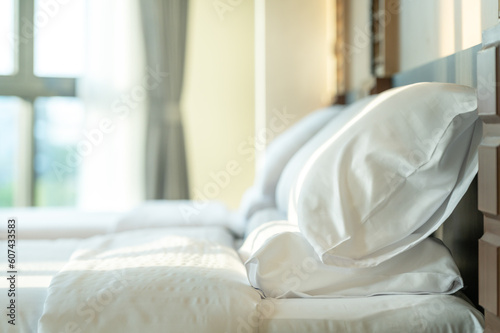 Soft pillows and white towel on clean white bed. Pillows bed with bedding sheets in bedroom. Bed sheets and pillows messed. Hotel, resort or home can relax on bed for deep sleep. © BESTIMAGE