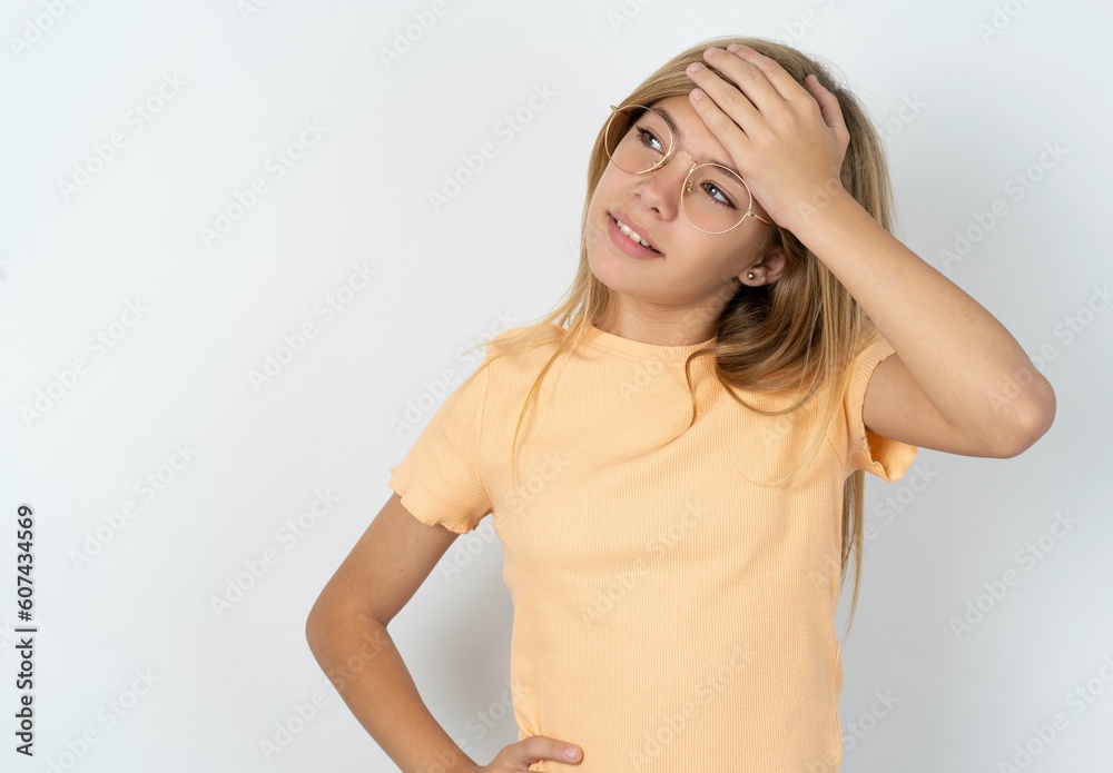 beautiful caucasian teen girl wearing orange T-shirt over white wall touching forehead, hears something surprising, glad receive good news, feels relieved. Almost got in trouble. beautiful caucasian teen girl wearing orange T-shirt over white wall touching forehead, hears something surprising, glad receive good news, feels relieved. Almost got in trouble.