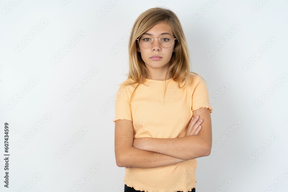 Picture of angry beautiful caucasian teen girl wearing orange T-shirt over white wall looking camera. Picture of angry beautiful caucasian teen girl wearing orange T-shirt over white wall looking camera.