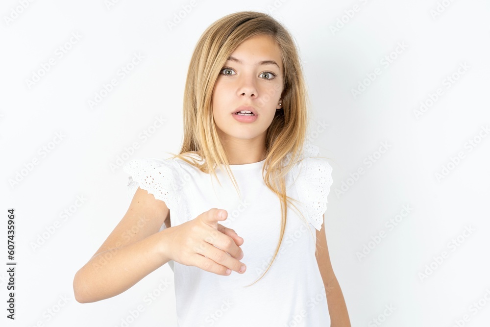 Shocked beautiful caucasian teen girl wearing white T-shirt over white ...