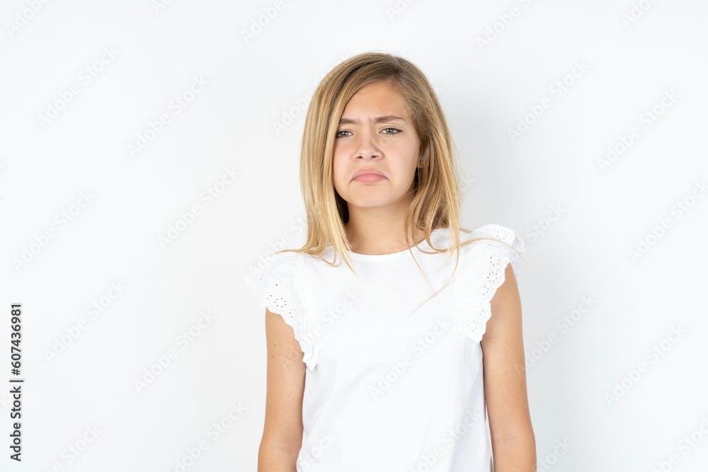 beautiful caucasian teen girl wearing white T-shirt over white wall depressed and worry for distress, crying angry and afraid. Sad expression. beautiful caucasian teen girl wearing white T-shirt over white wall depressed and worry for distress, crying angry and afraid. Sad expression.