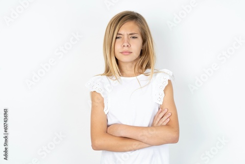 beautiful caucasian teen girl wearing white T-shirt over white wall Pointing down with fingers showing advertisement, surprised face and open mouth