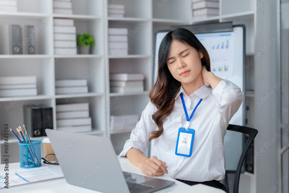 Asian businesswoman tired suffering from neck pain Back pain due to prolonged use of laptop computer at work. Asian businesswoman tired suffering from neck pain Back pain due to prolonged use of laptop computer at work.