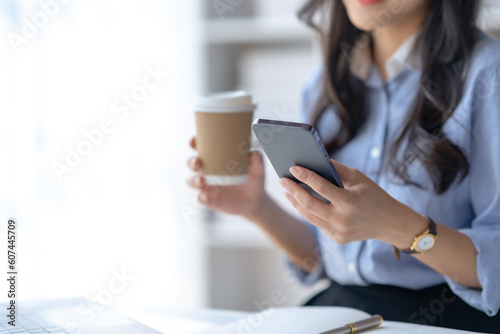 Close-up of a woman using a smartphone to work on various application including mobile transaction to send messages, LINE, and various business information sent via social media.