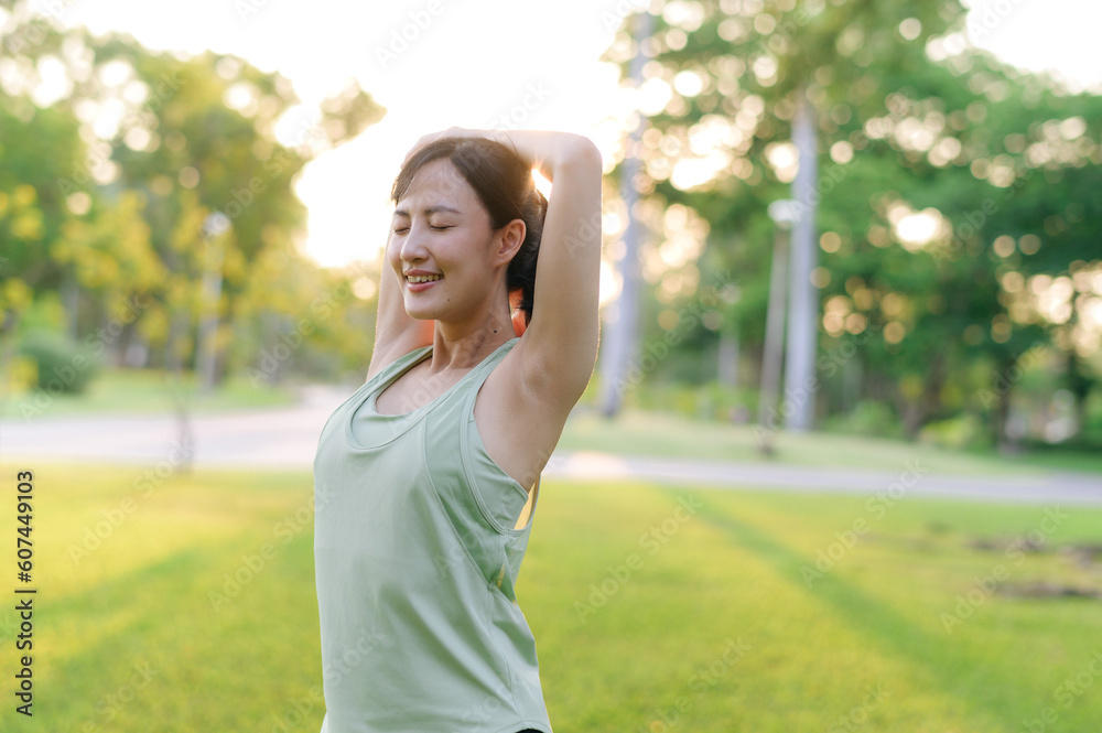 Female jogger. Fit young Asian woman with green sportswear stretching muscle in park before running and enjoying a healthy outdoor. Fitness runner girl in public park. Wellness being concept Female jogger. Fit young Asian woman with green sportswear stretching muscle in park before running and enjoying a healthy outdoor. Fitness runner girl in public park. Wellness being concept