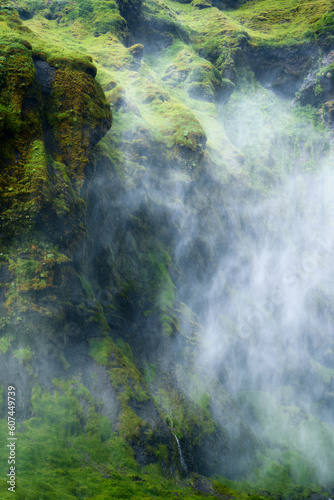 Mystery waterfall flowing with foggy in lush canyon