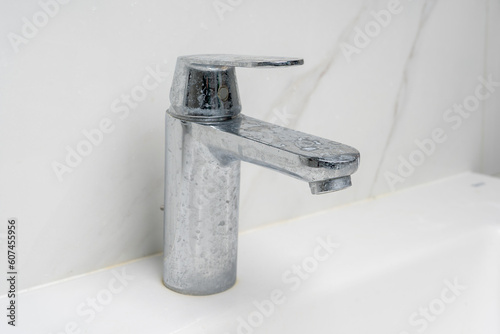 dirty water faucet covered in soap and limescale