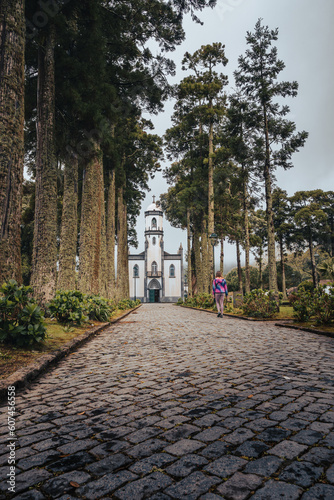 A person walking towards church. Igreja de Sao Nicolau, Azores