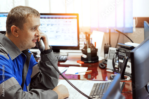 Tableau sur toile Telephone line operator answers phone and looks at computer monitor