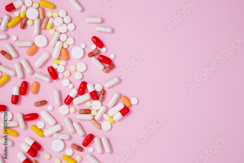 фотографія Various colorful medication tablets and capsules on pink background