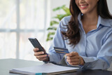 Beautiful Asian women using credit cards for shopping online with laptops and smartphones, online shopping portrait concept.