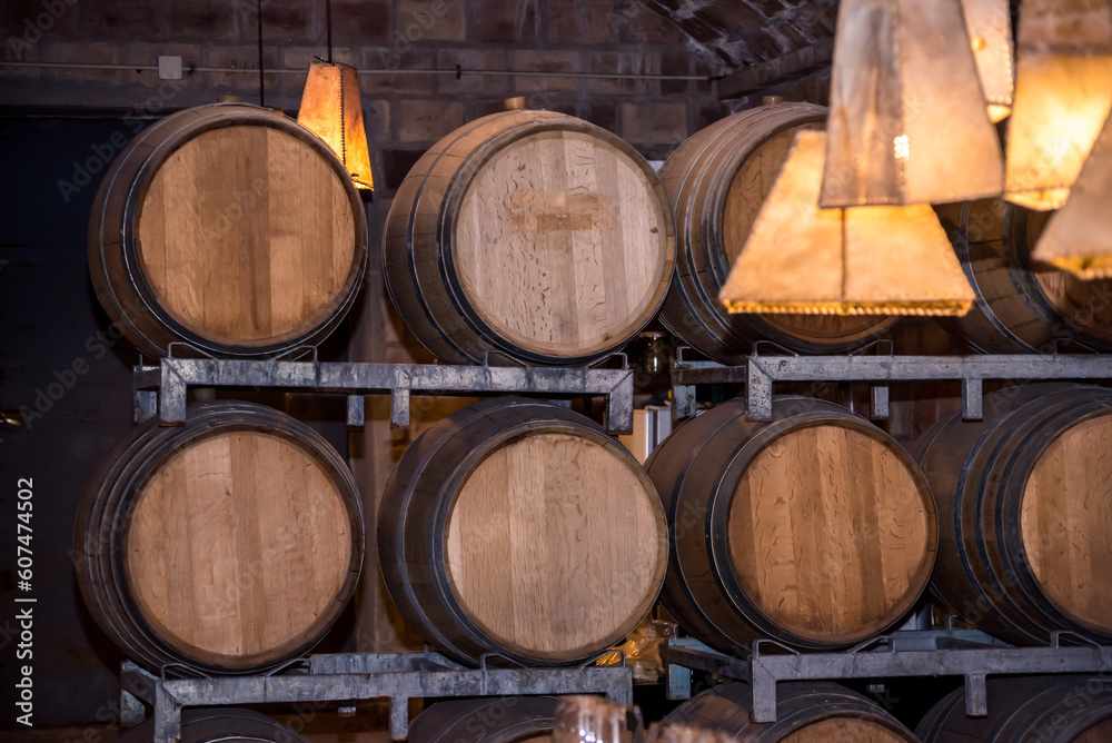 A row of wine barrels with a light hanging from the ceiling