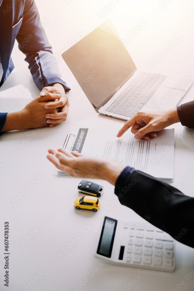 A car rental company employee is handing out the car keys to the renter ...