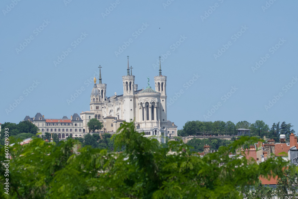 Basilica our lady of Fourvière in Lyon, France at the top of the fourvière hill with many trees in the foreground.