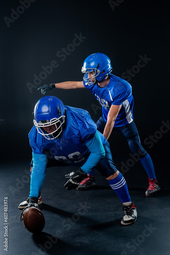 Two American football players are ready to start the game on a black background. 