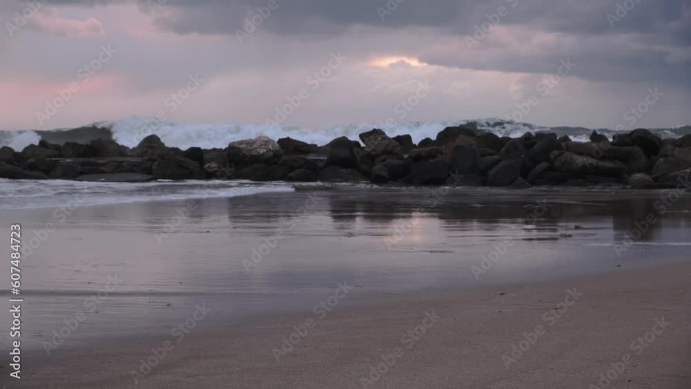 Stormy Mediterranean sea on a beach in Israel at dusk. Sea waves crash on the rocks of the coast