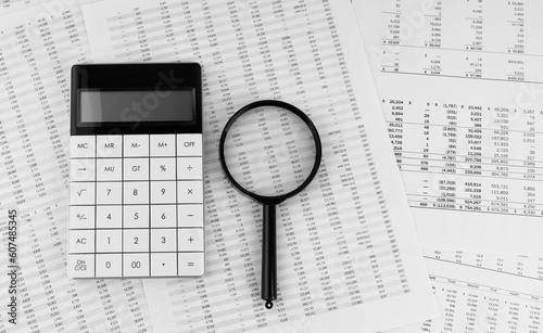 Calculator and magnifying glass on financial statement. Financial  accounting and business concept.