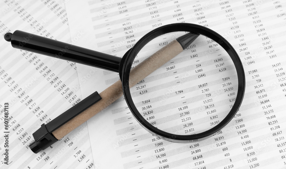 Magnifying glass and pen on financial statement. Magnifying glass and pen on financial statement.