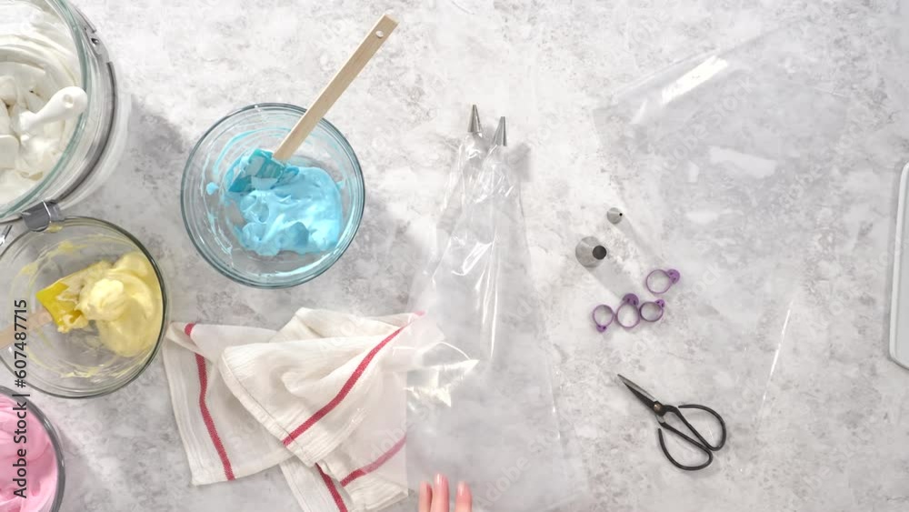 Time lapse. Flat lay. Step by step. Transfering meringue mix into piping bags with metal tips to bake unicorn meringue pops cookies. Time lapse. Flat lay. Step by step. Transfering meringue mix into piping bags with metal tips to bake unicorn meringue pops cookies.
