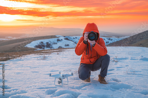 Konstfotografi a person in an orange jacket with black gloves is taking a picture of the object