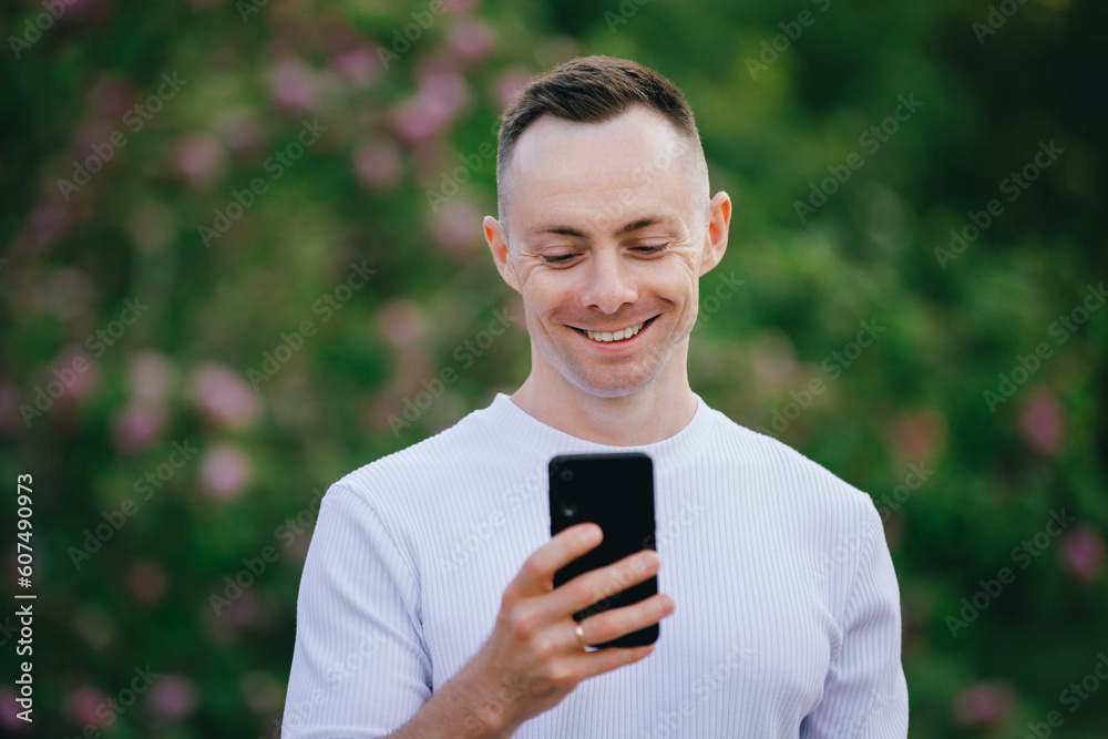 Closeup handsome man looking at mobile phone in the summer day Closeup handsome man looking at mobile phone in the summer day