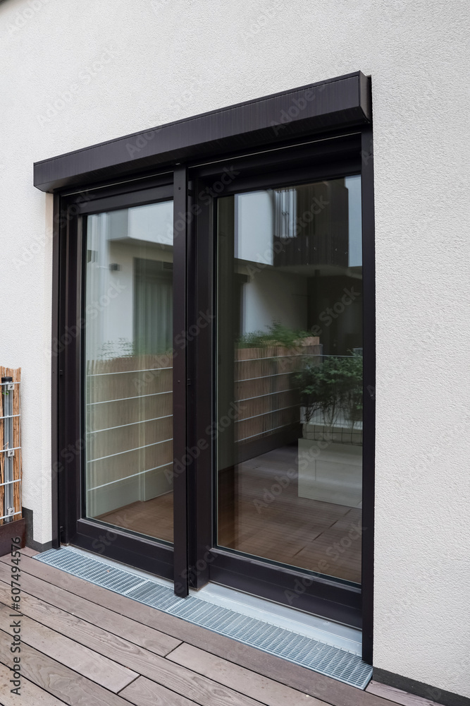 Fototapeta premium View of building with big windows and black roller shutters outdoors