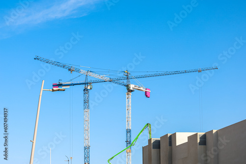 Construction cranes against blue sky